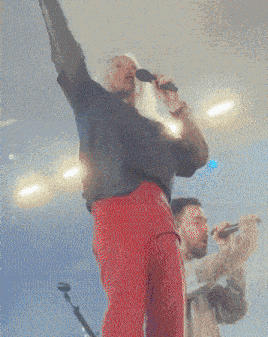 a man and woman singing into microphones on stage