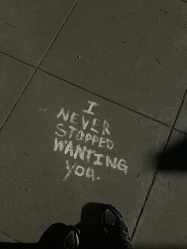 someone has written " i never stopped wanting you " in chalk on the sidewalk