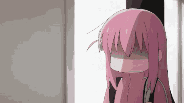 a girl with pink hair covering her face with her hands