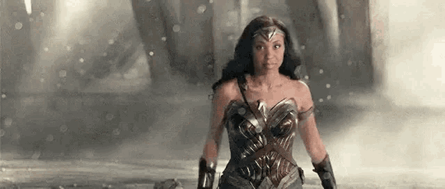 a woman in a wonder woman costume is standing on a snowy street .