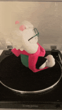 a stuffed animal is sitting on top of a turntable that says audio technica
