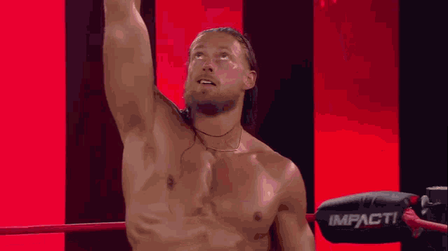 a shirtless wrestler in a ring with the word impact on the side