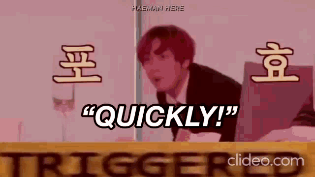 a man with red hair is sitting at a table with a laptop and says quickly .