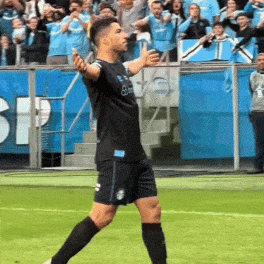 a soccer player wearing a black jersey that says bwin on it