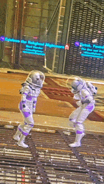two astronauts are dancing in front of a sign that says tik tok