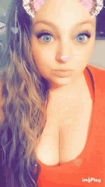 a woman with blue eyes is wearing a red top
