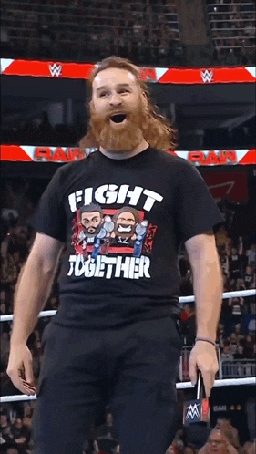 a man with a beard is wearing a black shirt that says fight together