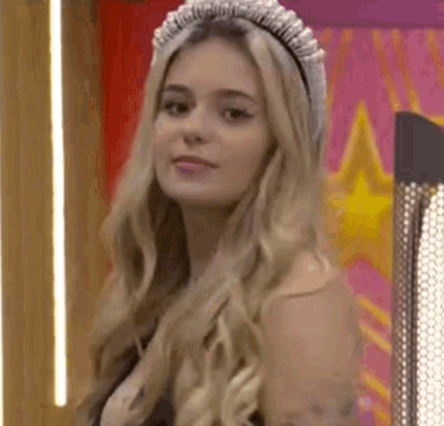 a close up of a woman wearing a headband and a black dress .