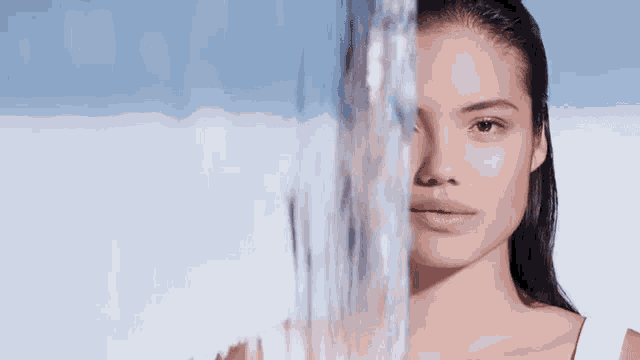 a close up of a woman 's face with water coming out of it .