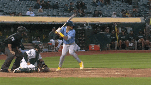 a baseball player is swinging at a pitch with a gatorade cooler behind him