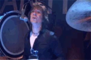 a man playing drums in front of a microphone