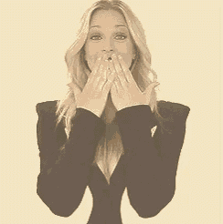 a woman in a black and white jacket is giving a thumbs up