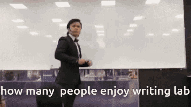 a man in a suit and bow tie stands in front of a white board with the words how many people enjoy writing lab