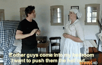 a man in a black shirt is talking to a woman in a white dress who is wearing a white head scarf