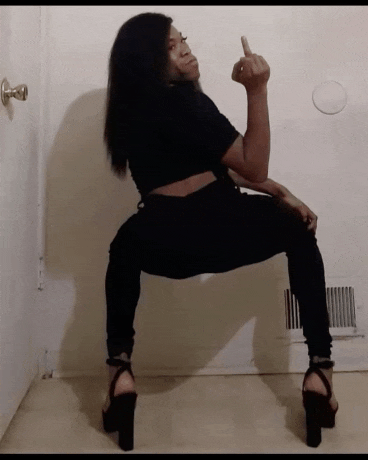 a woman giving the middle finger is wearing black pants and heels