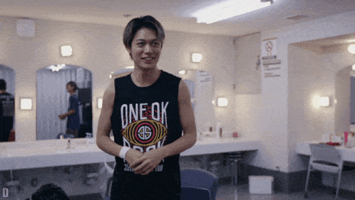 a man wearing a tank top that says one ok on it