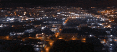 an aerial view of a city at night with a red arrow pointing to a store