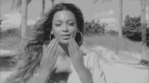 a black and white photo of a woman applying a cream to her face .