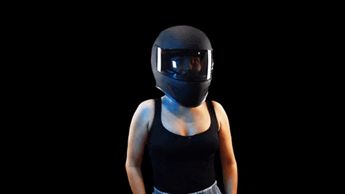 a woman wearing a motorcycle helmet is pointing her finger at something .