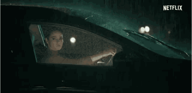 a woman is driving a car with a netflix logo on the bottom right