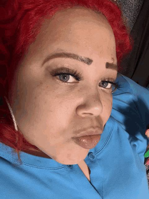 a close up of a woman 's face with red hair and blue eyes