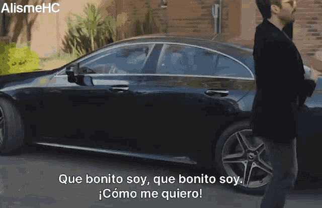 a man standing in front of a black car with the words que bonito soy on the bottom