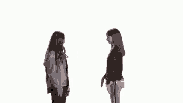 two young girls are dancing together in front of a white background .