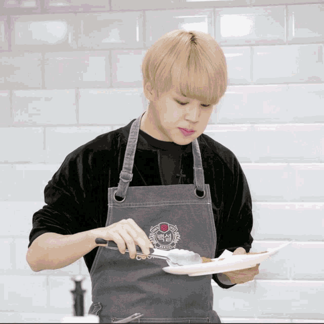 a man wearing an apron is holding a plate and a knife