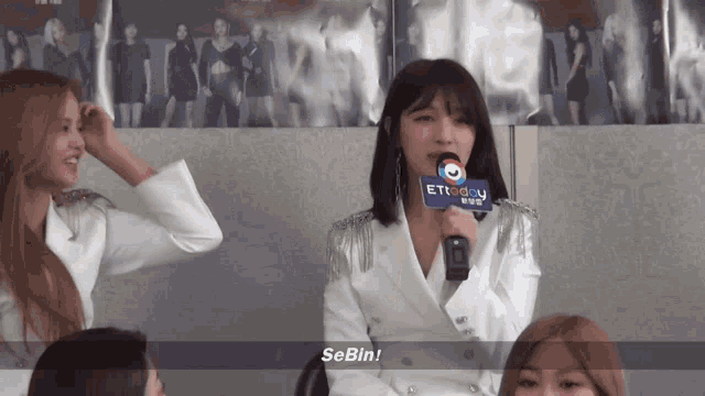 a woman holding a microphone with the word sebin on the screen