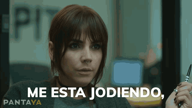 a woman with a nose ring is holding a pair of scissors and says me esta jodiendo pantaya