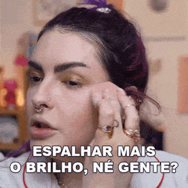 a woman with purple hair is applying makeup with the words espalhar mais o brilho ne gente below her