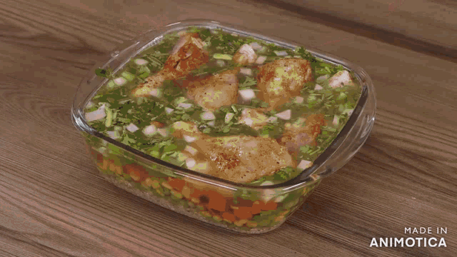 a glass bowl filled with chicken legs is being poured with warm water