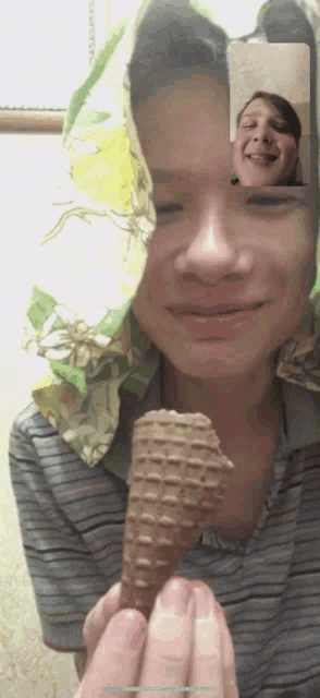 a person holding an ice cream cone in front of their face while on a video call