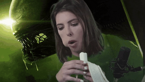 a woman eating an ice cream cone in front of a green alien