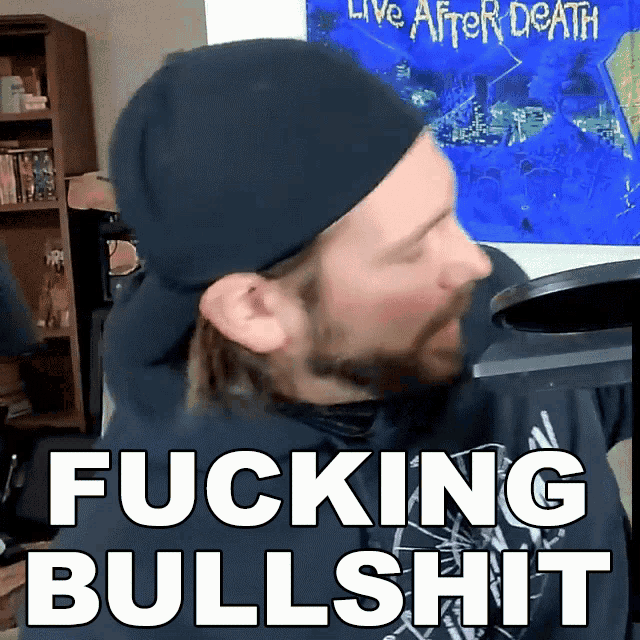 a man wearing a black hat stands in front of a microphone and says fucking bullshit