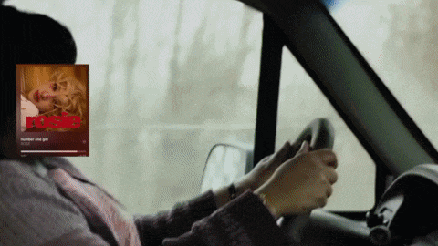 a woman is driving a car with a picture of a woman behind her that says number one girl on it