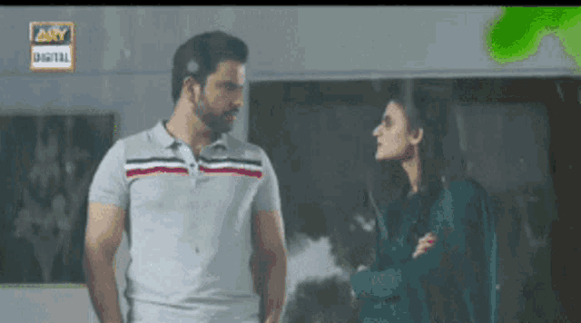 a man and a woman are standing next to each other with a sign that says ary digital