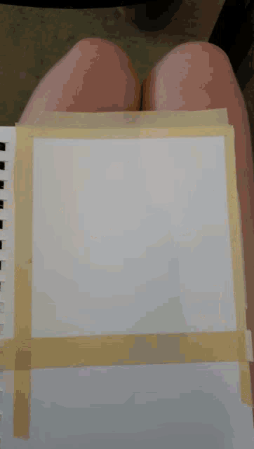a piece of paper is taped to a person 's knee