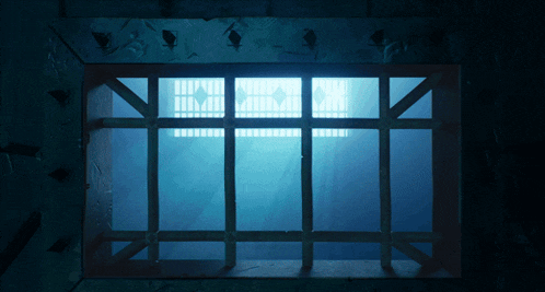 a dark room with a light shining through a window