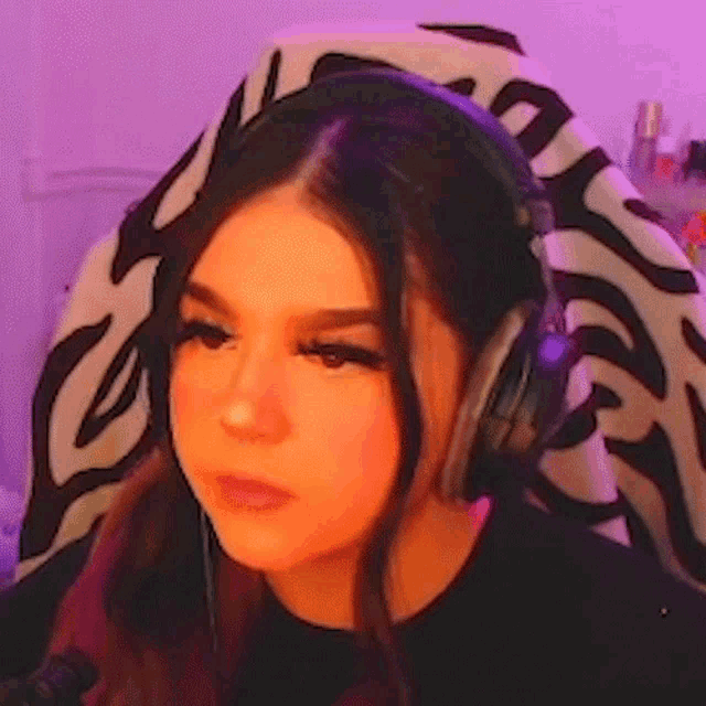 a young woman wearing headphones is sitting in a chair .