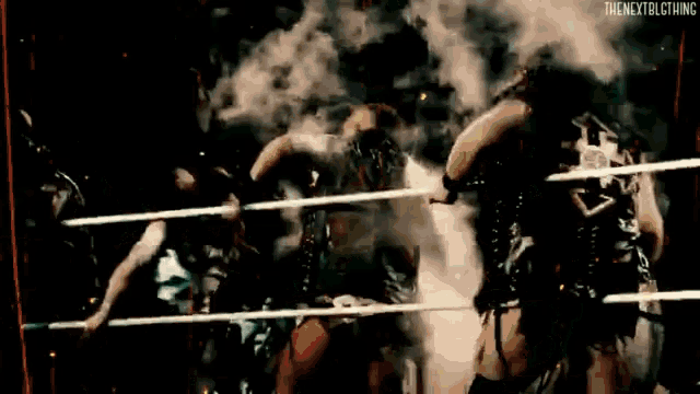 a group of wrestlers are in a ring with smoke coming out of it