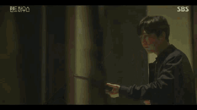 a man is holding a gun in a hallway with sbs written on the bottom