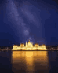 a blurry picture of a city at night with a starry sky in the background