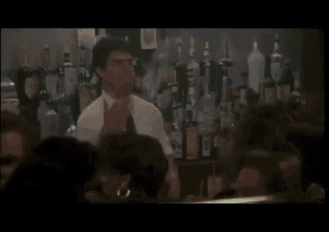 a man in a white shirt and tie is standing at a bar