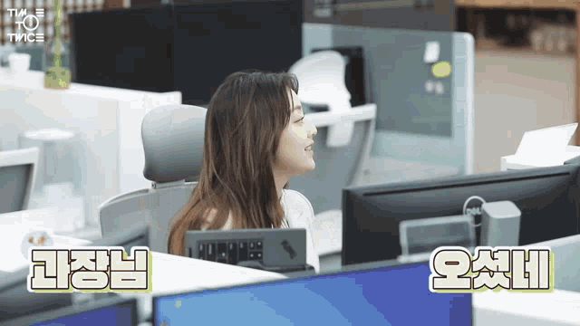 a woman sitting in front of a dell computer monitor