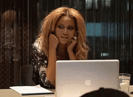 a woman is sitting in front of a laptop computer