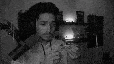 a black and white photo of a man wearing headphones and holding a toy .