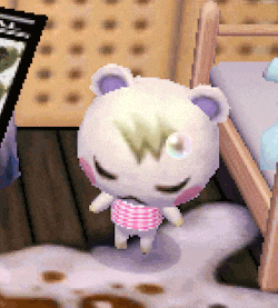 a stuffed animal with a w on its head is standing next to a bed .