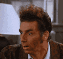 a close up of a man 's face with his mouth open and a lamp in the background .