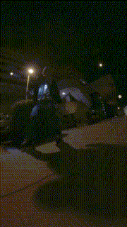 a person walking down a sidewalk at night